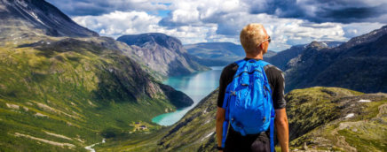 Image of man hiking overlooking a mountain lake